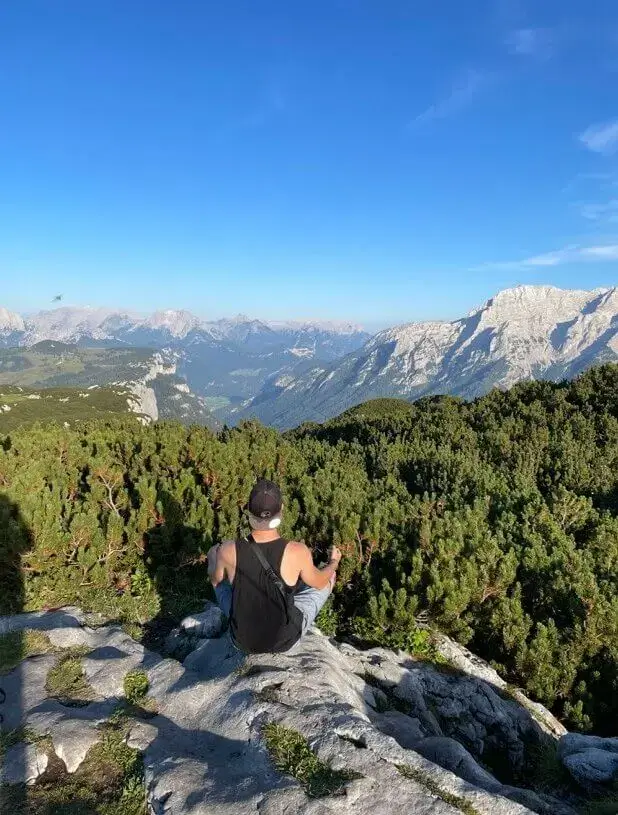 Meditieren in den Bergen: eine Person meditiert hoch im Gebirge und genießt die Schönheit der Mutter Natur.