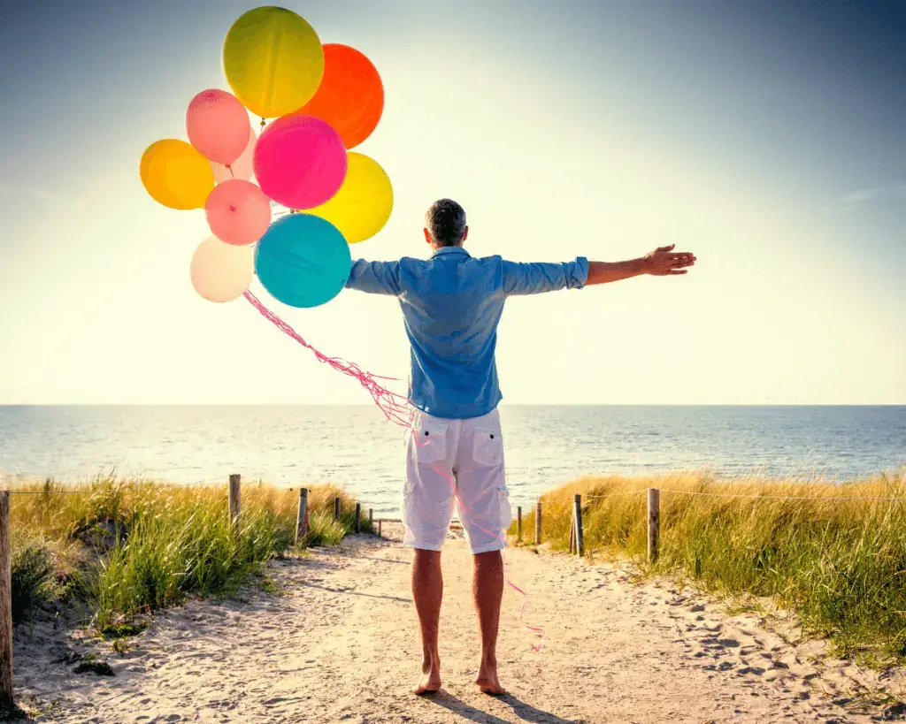 Ein Junge mit Ballons auf dem Weg zum Meer um auszuruhen und FOMO zu bewältigen.