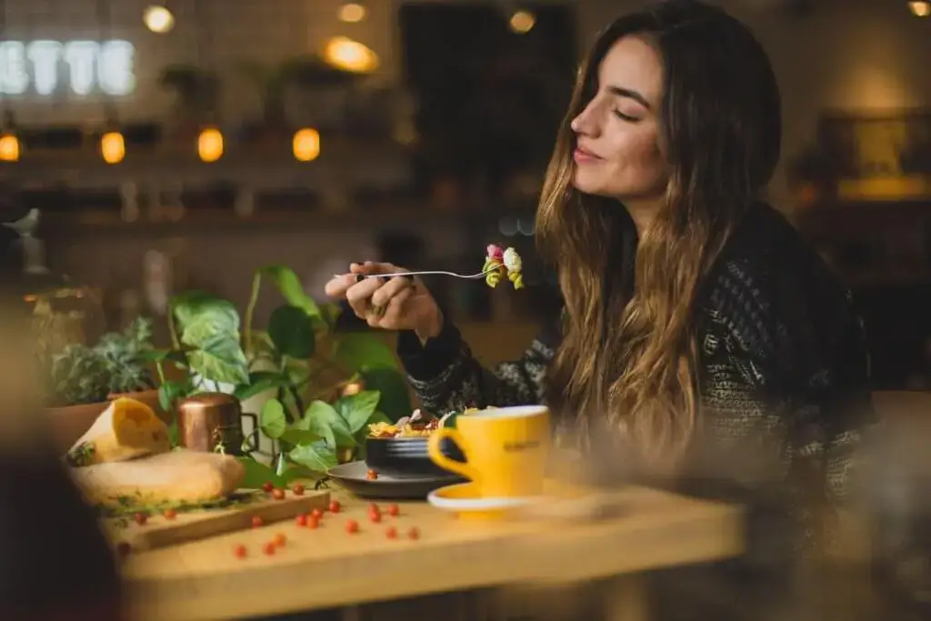 Achtsamkeit während des Essens: ein Mädchen, das Früchte und Gemüse isst und sich entspannt.
