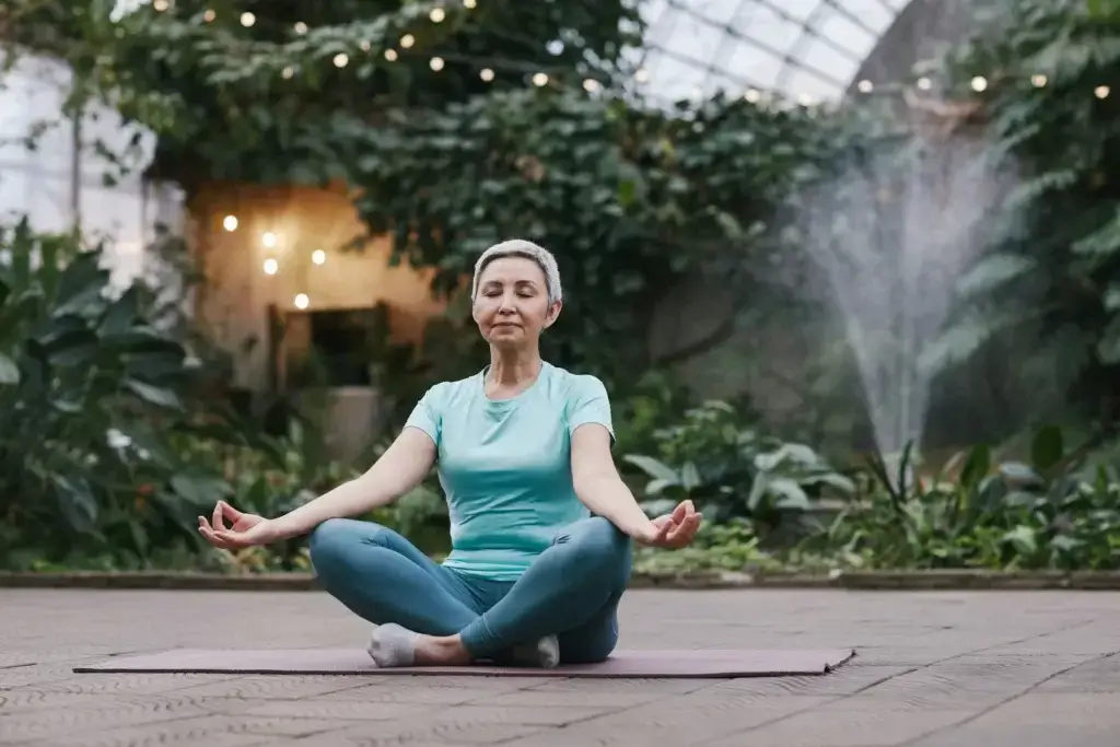 Eine alte Frau, die auf dem Boden Meditation macht, um ihr Gehirn zu entwickeln.