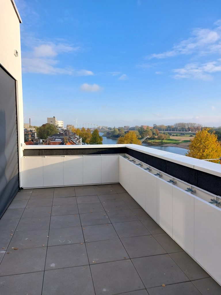 Dakterras in Arnhems Blond Huis met plantenbakken en zicht op de John Frostbrug