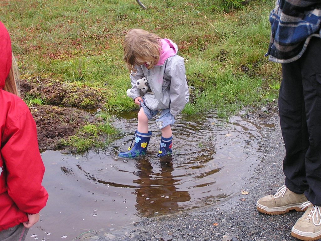 Regen, Kind in Pfütze Norwegen Jøssåsen landsbyauswandern nach norwegen