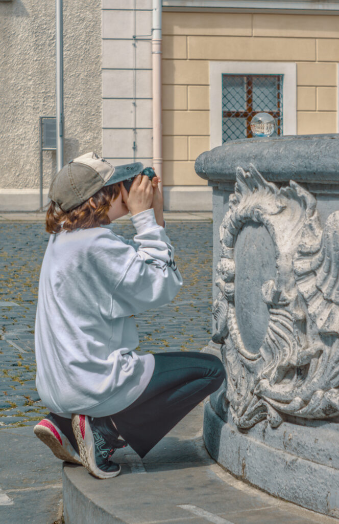 Kind beim Fotografieren einer Glaskugel