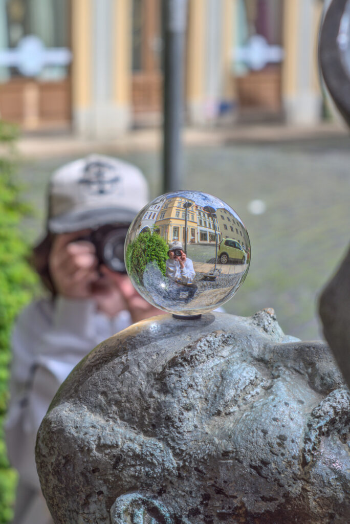 Das Kind fotografiert eine Glaskugel