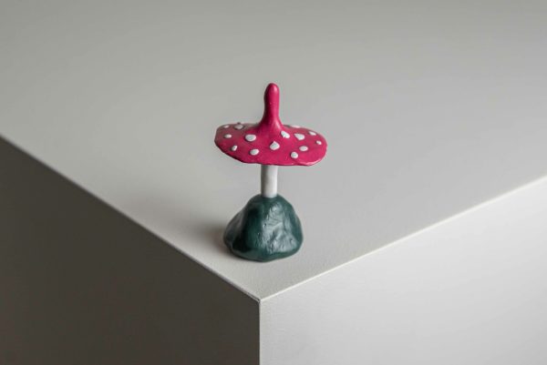 A polymer clay figurine of a red mushroom with white dots by Mitsuo