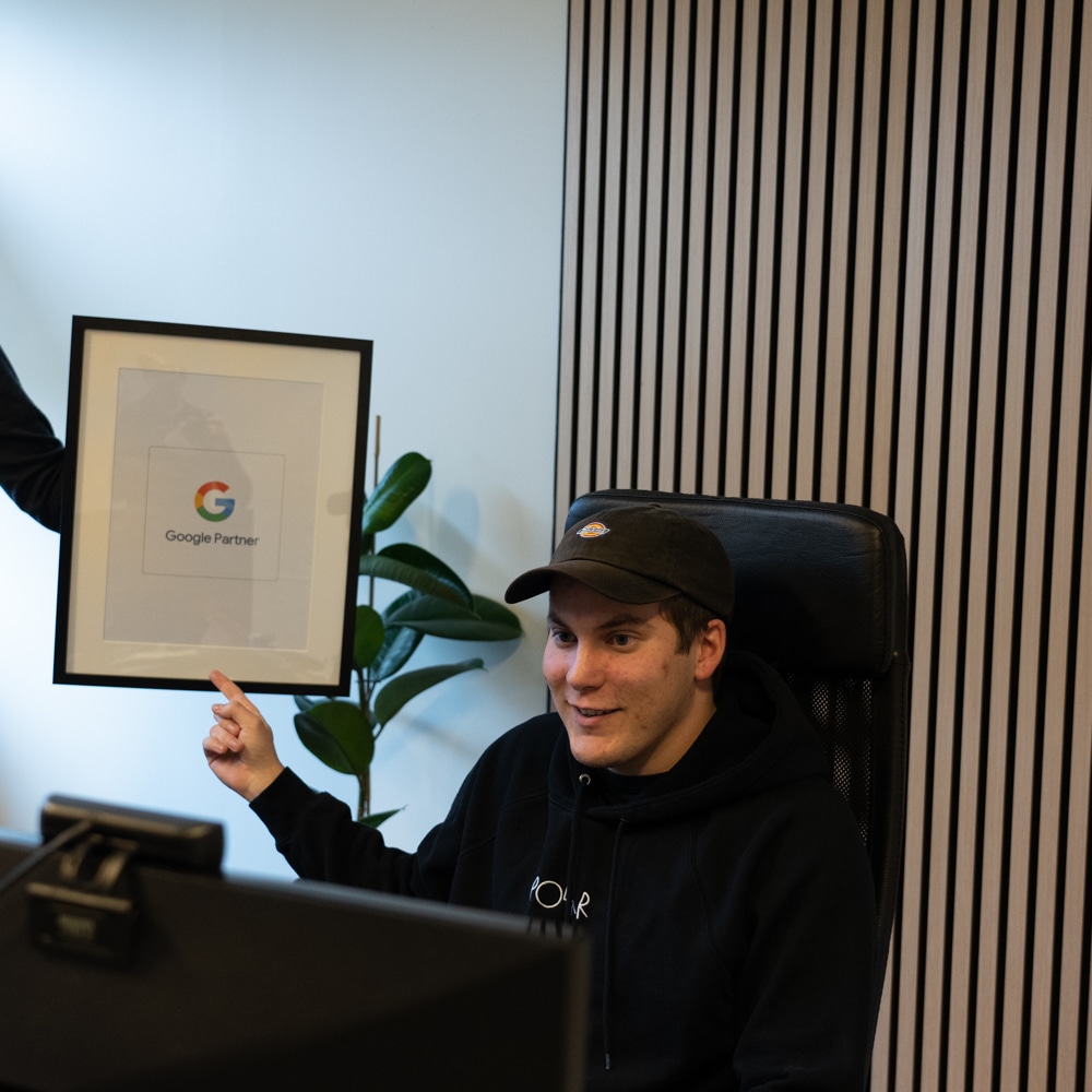 Gustaf pekar på Google Partner loggan som Kalle håller upp