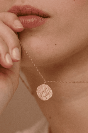 woman wearing the Pisces Necklace by the brand Agape Studio