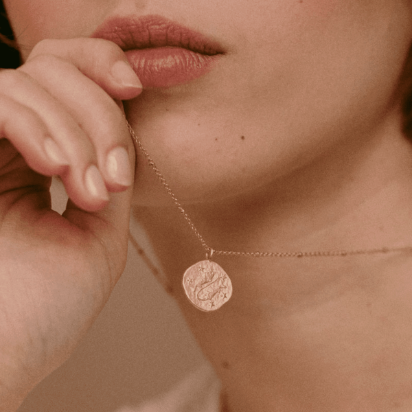 woman wearing the Pisces Necklace by the brand Agape Studio