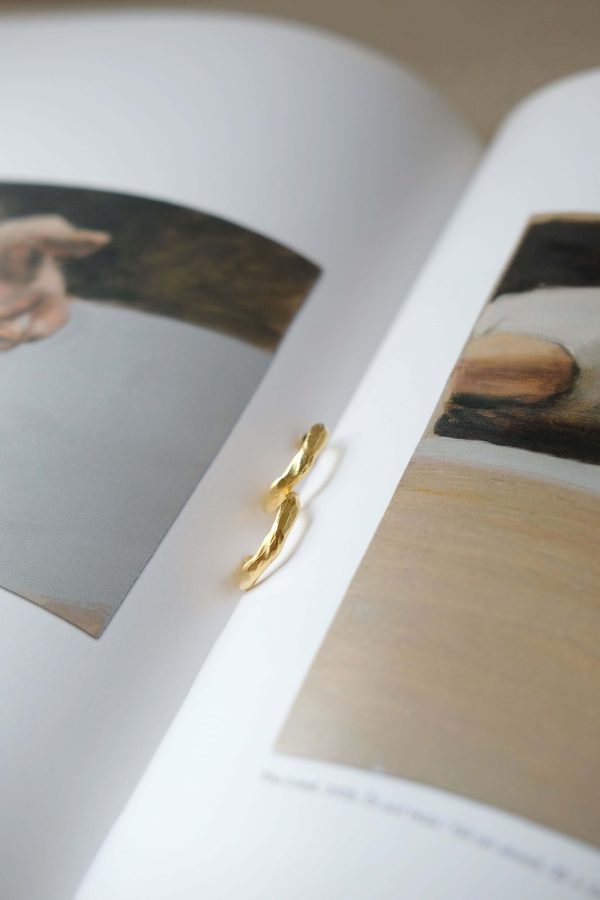 the Zephir Earrings by the brand Agapé Studio shown on a book