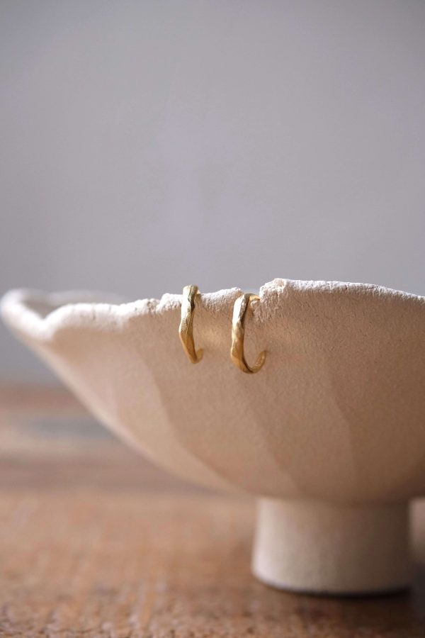 the Zephir Earrings by the brand Agapé Studio on a ceramic vessel by Marlies Huybs