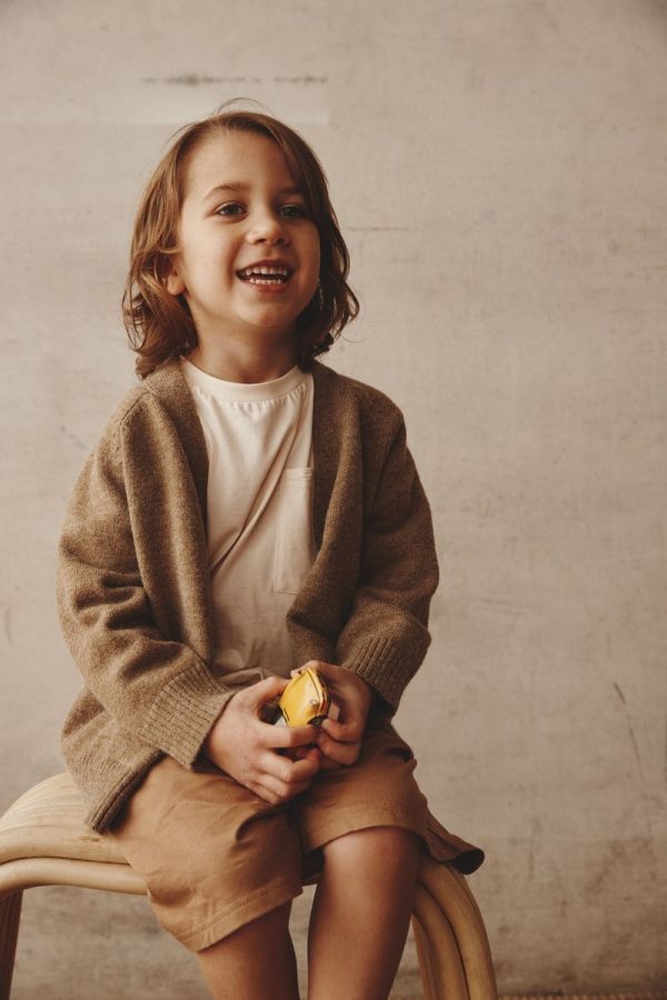 boy wearing the Dorothy Cardigan in Khaki by the brand Alfred