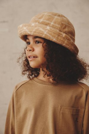 girl wearing the Joan Check Bucket Hat in beige & the Duncan Longsleeve in Khaki by the brand Alfred