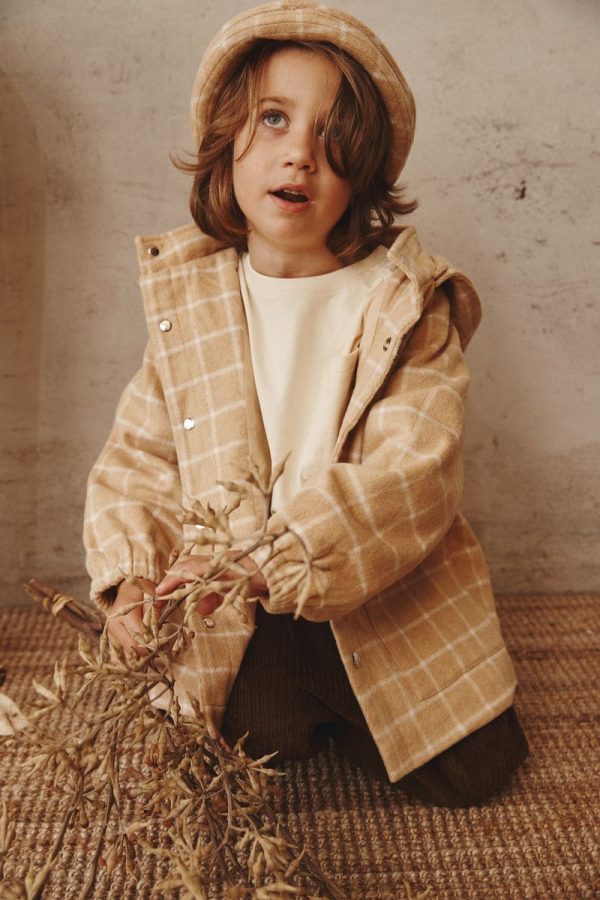 boy wearing the Joan Check Jacket in beige by the brand Alfred