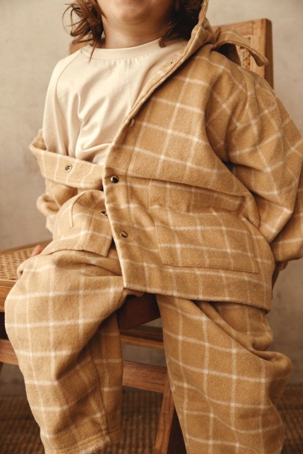 boy wearing the Joan Check Jacket in beige by the brand Alfred