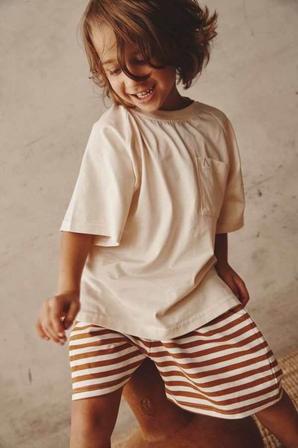 boy wearing the Lucia Shorts in Chocolate paired with the Walter Tee in Cream by the brand Alfred