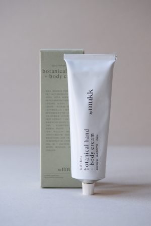 front view of the Botanical Hand & Body Cream of By Mukk, showing the product out of the box with main ingredients listed in front