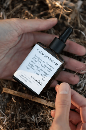 Someone holding the Calm Sea Serum of By Mukk in their hands, showing the size of the product as well as the aesthetically pleasing design