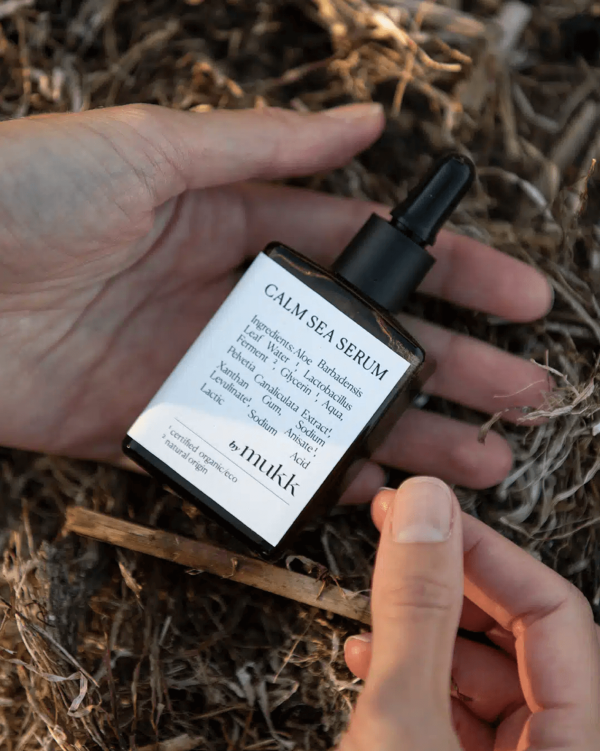 Someone holding the Calm Sea Serum of By Mukk in their hands, showing the size of the product as well as the aesthetically pleasing design