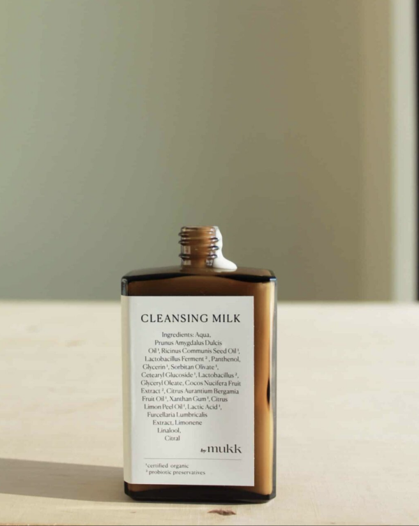 An open bottle of Cleansing Milk by By Mukk showing the milky consistency