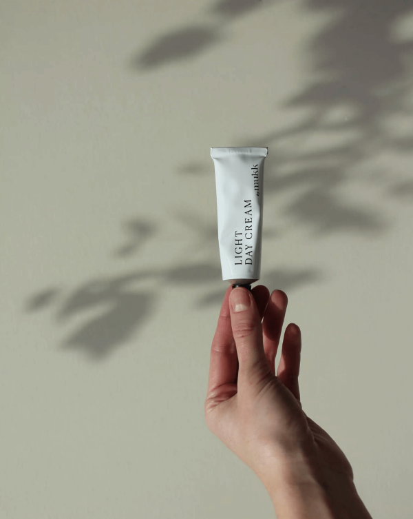 someone holding the Light Day Cream of By Mukk in a tree's shadow showing the designer's biggest inspiration, nature