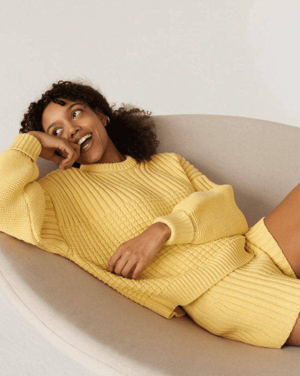 woman wearing the Delcia Sweater in Lemon by the brand The Knotty Ones