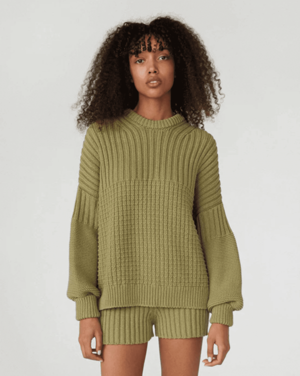 woman wearing the Delcia Sweater in Olive by the brand The Knotty Ones