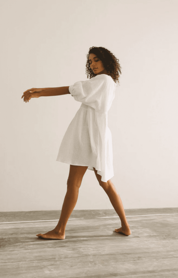 Woman wearing the Eden Dress in White by the brand The Bare Road