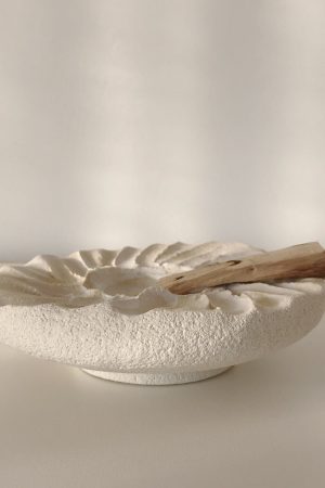 Side view of the Siipi Tray by Marlies Huybs showing the floating tray on a smaller sole styled with palo santo