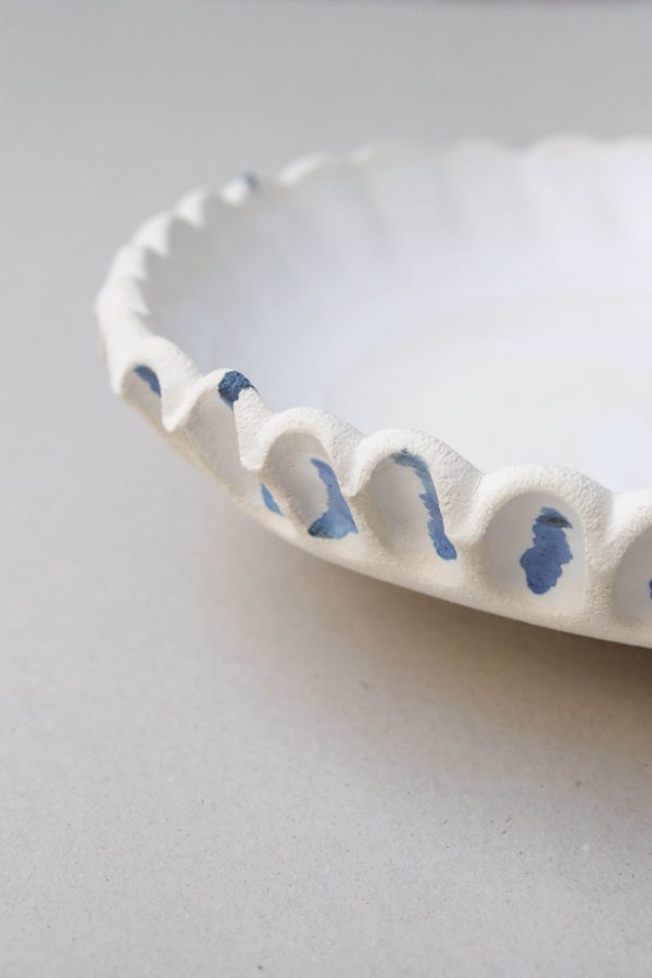 Detail of the textural and organic curves of the ceramic XL Moon Bowl Anemone by Marlies Huybs showing the blue and beige colour palette