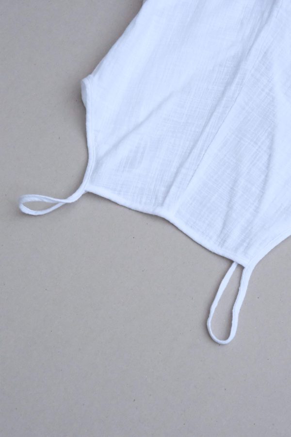 Detailed closeup of the front of the Flo Jumpsuit in White by Bahhgoose, showing the straps and the square neckline