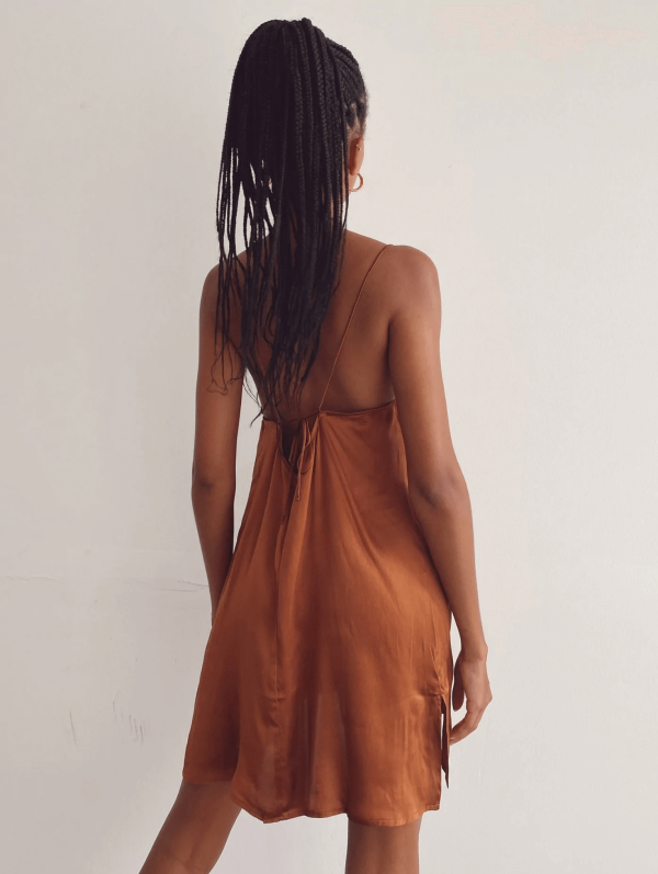 back view of a woman wearing the Jai Dress in Coco by the brand Bahhgoose, showing the open back and the adjustable tie straps