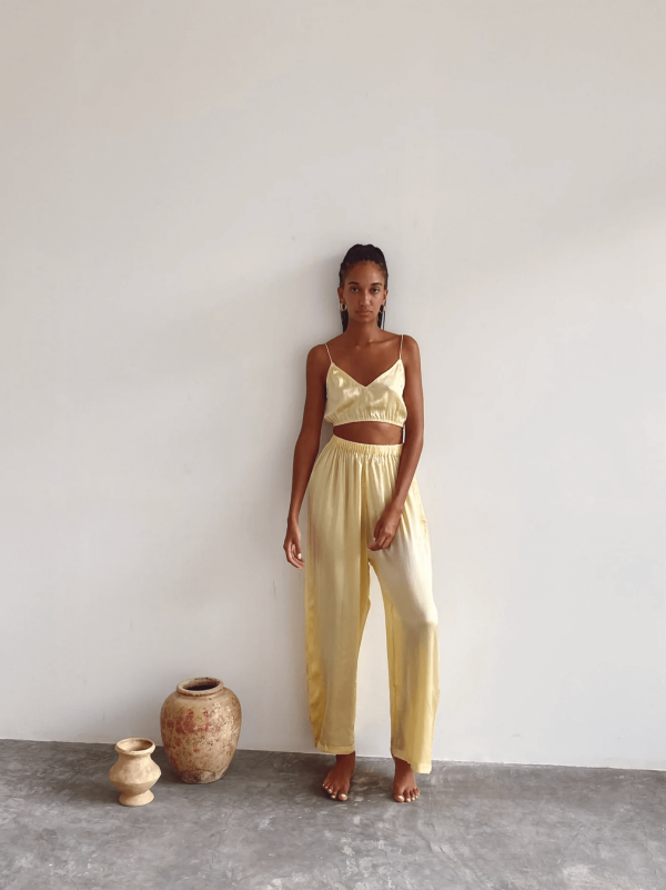 a woman wearing the silk Jai Pants & Jai Top in Yellow by the brand Bahhgoose, showing the relaxed fit and the silky fabric