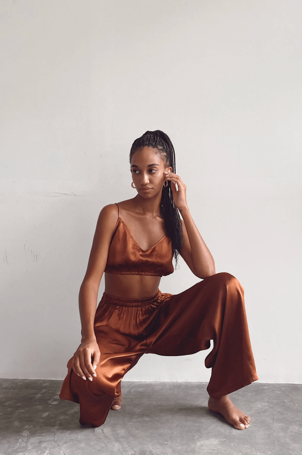 a woman sitting while wearing the Jai Top in Coco with matching Jai Pant, by the brand Bahhgoose, showing the relaxed co-ord set