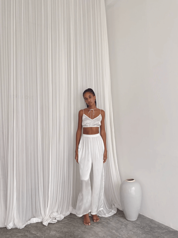 a woman wearing the Jai Top with the matching Jai Pants in White by the brand Bahhgoose, showing the relaxed fit of this beautiful co-ord set