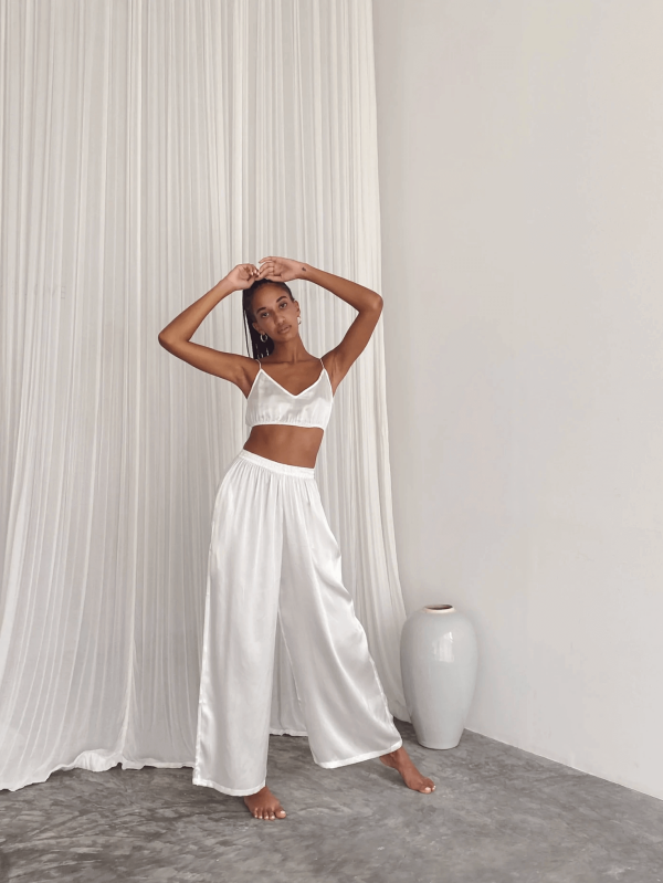 a woman wearing the Jai Top with the matching Jai Pants in White by the brand Bahhgoose, showing the relaxed fit of this beautiful co-ord set