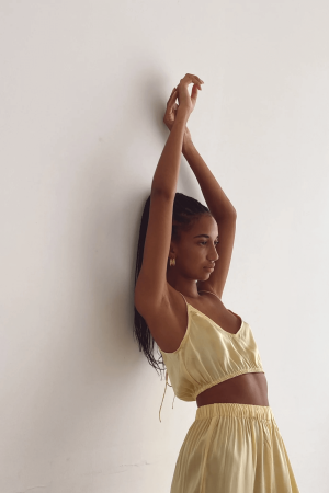 Closeup of a woman wearing the Jai Top with the matching Jai Pants in Yellow by the brand Bahhgoose, showing the relaxed fit of this beautiful co-ord set