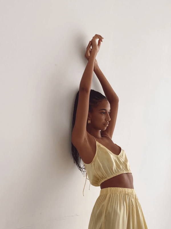 Closeup of a woman wearing the Jai Top with the matching Jai Pants in Yellow by the brand Bahhgoose, showing the relaxed fit of this beautiful co-ord set