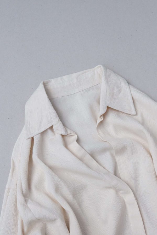 flatlay of the Ker Button Up in Natural by the brand Bahhgoose, showing the collar and the textured fabric
