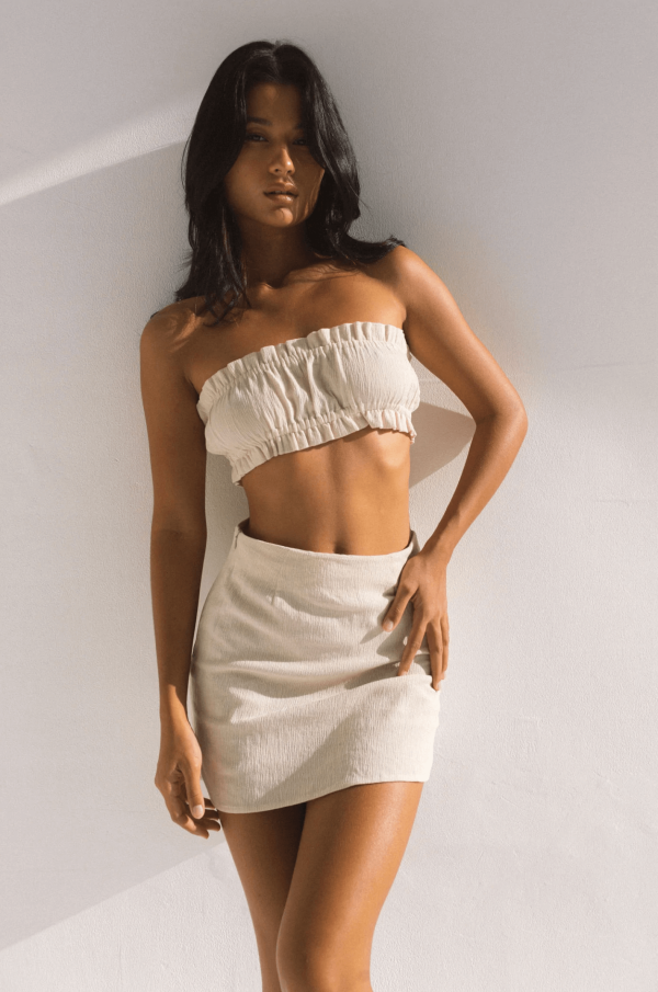 woman wearing the Ona skirt in Natural with matching top by the brand Bahhgoose