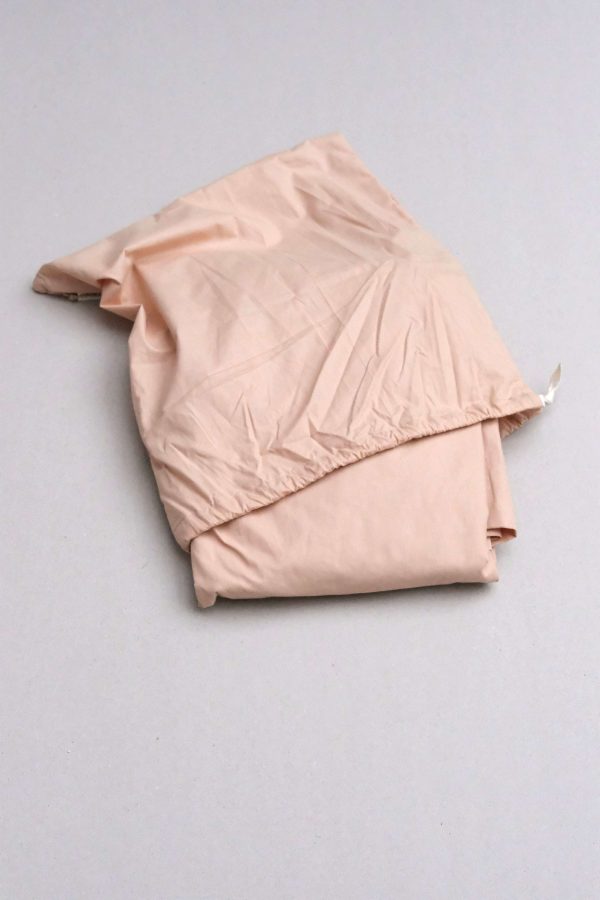 flatlay of the Base Cotton Fitted Bedsheet in Nude Pink by the brand Cats and Boys