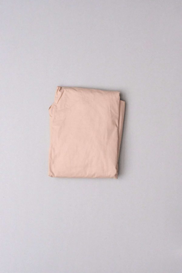 flatlay of the Base Cotton Fitted Bedsheet in Nude Pink by the brand Cats and Boys