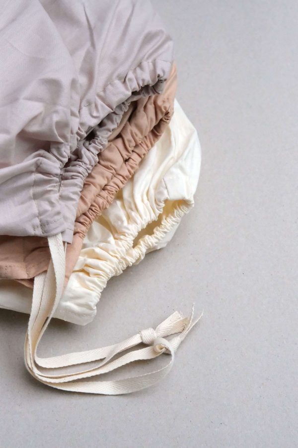flatlay of the Base Cotton Fitted Bedsheets in Nude Pink,Sand & Vanilla by the brand Cats and Boys