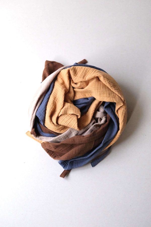 flatlay of the muslin gauze cotton dishtowels in Rust,Honey, blue & Caramel by the brand Cats and Boys