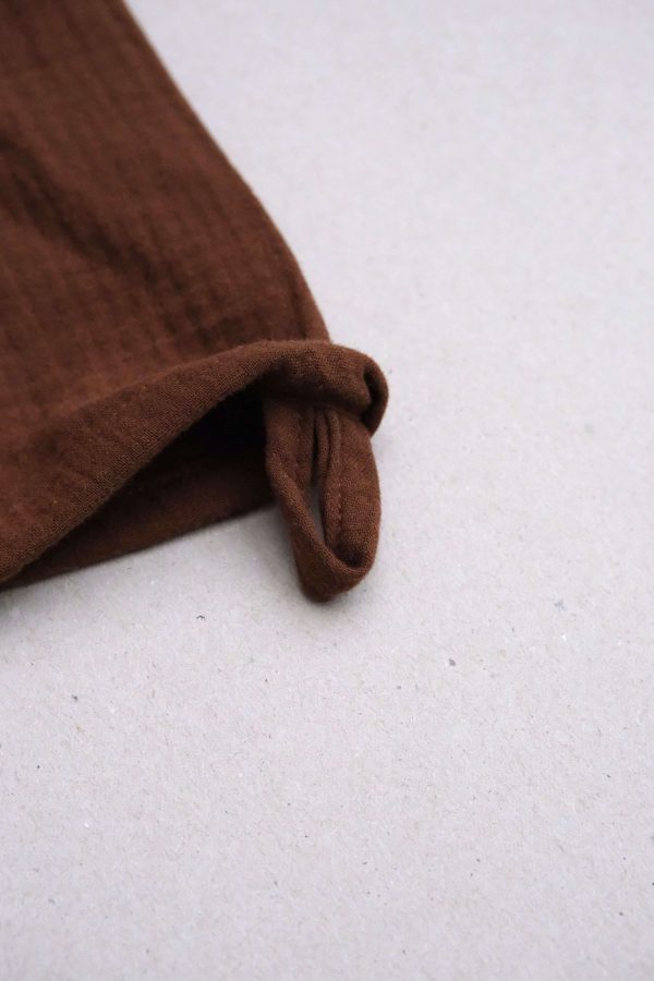 flatlay of the muslin gauze cotton dishtowel in Rust by the brand Cats and Boys
