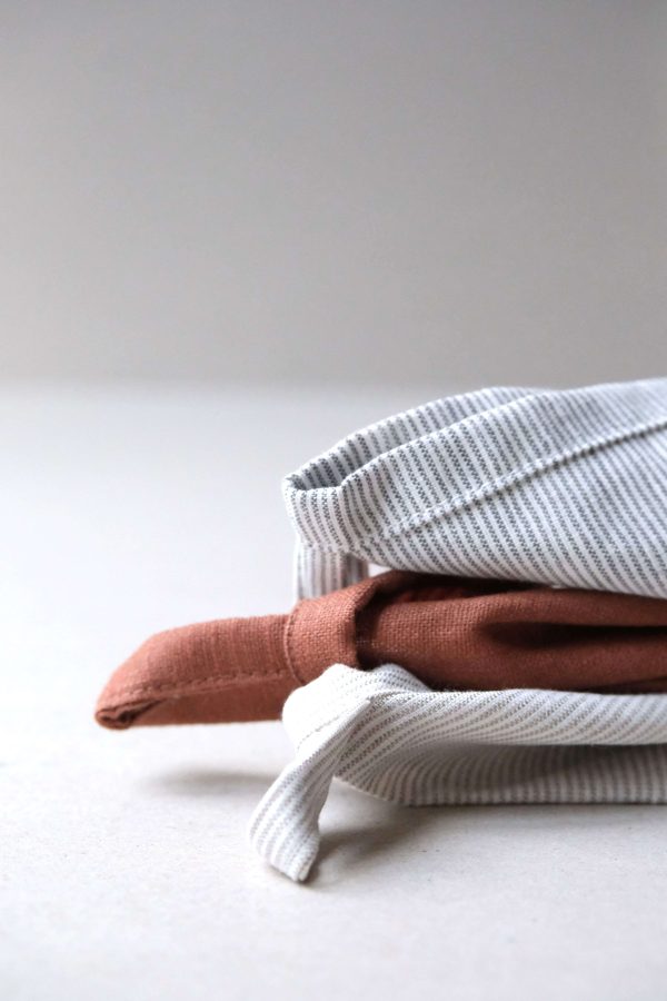 flatlay of the linen dishtowel in Rust, Natural & Grey Stripes by the brand Cats and Boys