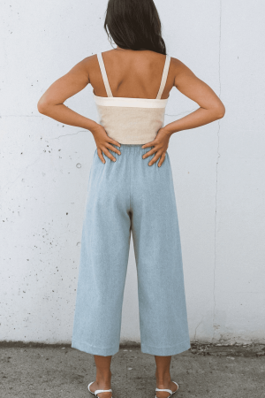 woman wearing the cotton Aura Pants in Light Denim by the brand Harly Jae