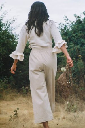 woman wearing the organic/linen Aura Pants in Natural by the brand Harly Jae