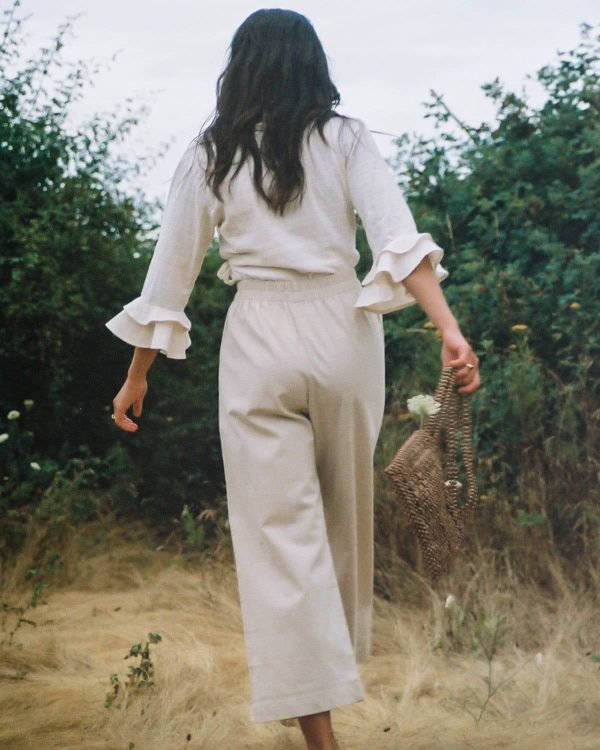 woman wearing the organic/linen Aura Pants in Natural by the brand Harly Jae