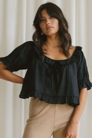 woman wearing the organic cotton Doll Blouse in Black by the brand Harly Jae