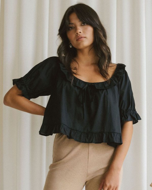 woman wearing the organic cotton Doll Blouse in Black by the brand Harly Jae